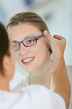 Young woman trying on eyeglasses