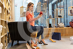 Young woman trying high heeled shoes at store