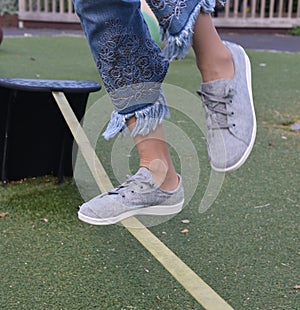 Young woman is trying to balance on a walking rope