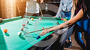 Young woman trying to hit the ball in billiard.