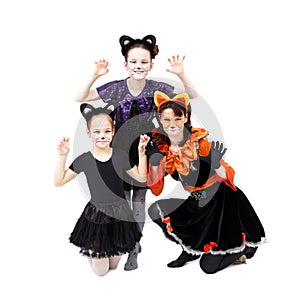 Young woman and two girls in cat carnival costumes posing