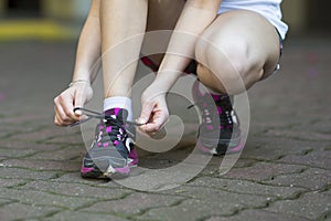 Young woman is tying the laces before running.
