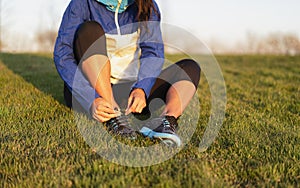 Young woman tying shoelace of sneakers to make outwork training running. Fitness and healthy lifestyle