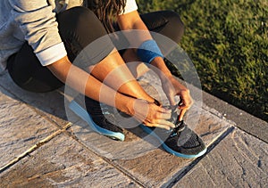 Young woman tying shoelace of sneakers to make outwork training running. Fitness and healthy lifestyle