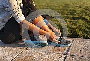 Young woman tying shoelace of sneakers to make outwork training running. Fitness and healthy lifestyle photo