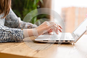 Young woman Typing on the keyboard, chatting, maintains a blog. Freelancer work in modern coworking. Successful people