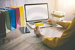 Young woman typing laptop for online shopping website and holding card pay by credit card, Online payment and shopping concept