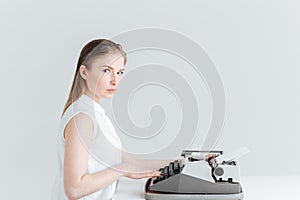 Young woman typing on retro machine