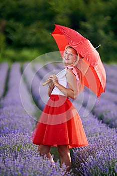 Young woman with umbrella in lavender field