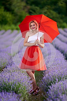 Young woman with umbrella in lavender field