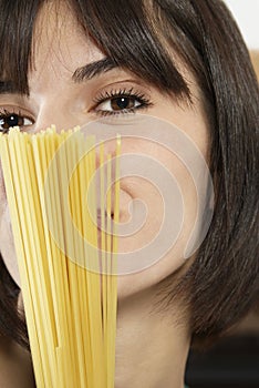 Young Woman With Uncooked Spaghetti