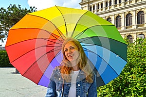 The young woman under an iridescent umbrella in summer day