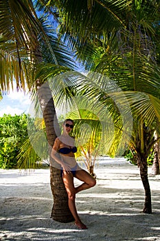 Young woman under the palm tree at tropical beach