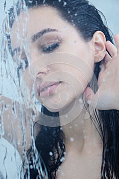 Young woman under shower with water drops