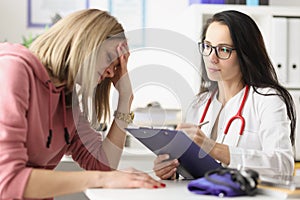 Young woman under stress from medical diagnosis at clinic appointment