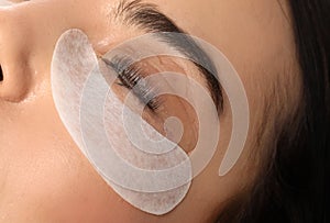 Young woman undergoing eyelash lamination, closeup. Professional service