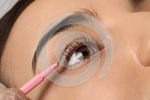 Young woman undergoing eyelash lamination, closeup. Professional service