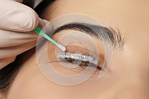 Young woman undergoing eyelash lamination, closeup. Professional service