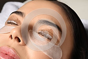 Young woman undergoing eyelash lamination. Professional service