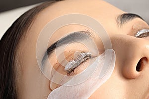 Young woman undergoing eyelash lamination. Professional service