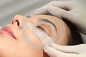 Young woman undergoing eyelash lamination. Professional service