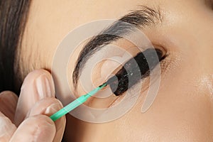 Young woman undergoing eyelash lamination and tinting