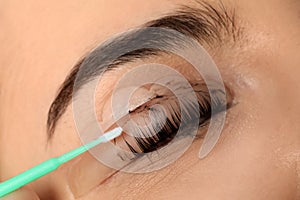 Young woman undergoing eyelash lamination and tinting, closeup