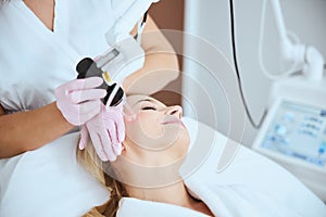 Young woman undergoing a non-invasive cosmetic procedure photo