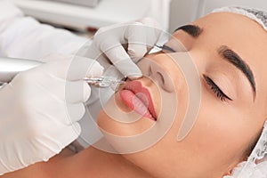 Young woman undergoing procedure of permanent lip