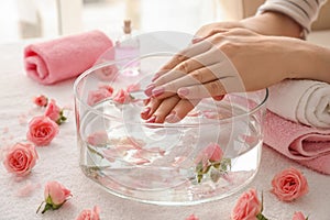 Young woman undergoing spa manicure treatment in beauty salon