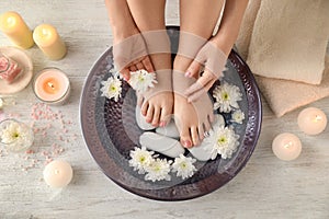 Young woman undergoing spa pedicure treatment in beauty salon