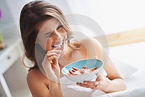 Young woman in underwear eating cereals