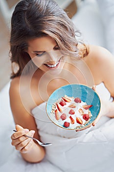 Young woman in underwear eating cereals