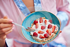 Young woman in underwear eating cereals