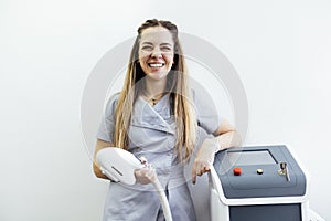 Young woman in uniform stands next to a professional photoepilation machine
