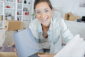 Young woman unpacking box in new home