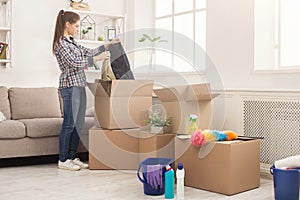 Young woman unpacking boxes after moving