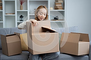 Young Woman Unpacking Boxes In New Home, Feeling Happy photo