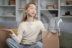 Young Woman Unpacking Clothes In New Apartment photo