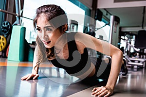 Young woman up and doing some push ups in fitness gym