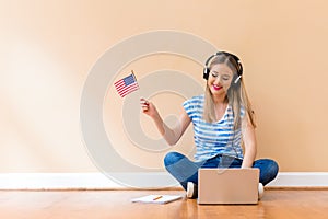 Young woman with USA flag using a laptop computer