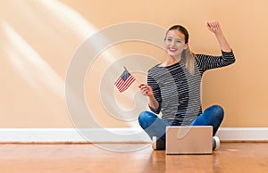 Young woman with USA flag using a laptop computer