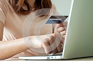 Young woman use credit card for shopping payment online on laptop computer application or website. E-commerce and online shopping