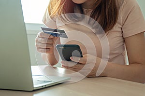 Young woman use credit card for shopping  payment online on laptop computer application or website. E-commerce and online shopping