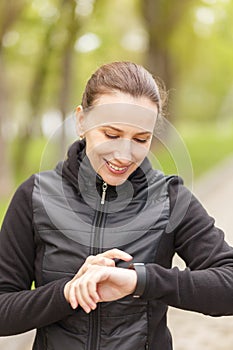 Young woman use fitness smart watch after jogging