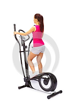 Young woman uses elliptical cross trainer.