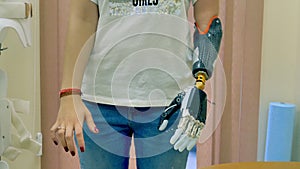 Young woman uses innovative robotic bionic arm. 4K.