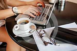 Young woman uses laptop in cafe