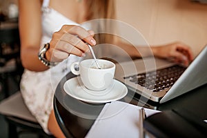 Young woman uses laptop in cafe