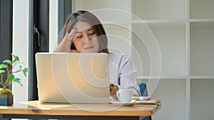 A young woman uses a laptop for work,She works from home and is tired